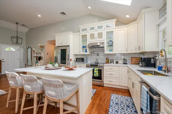 a kitchen with stainless steel appliances kitchen island granite countertop a sink and cabinets