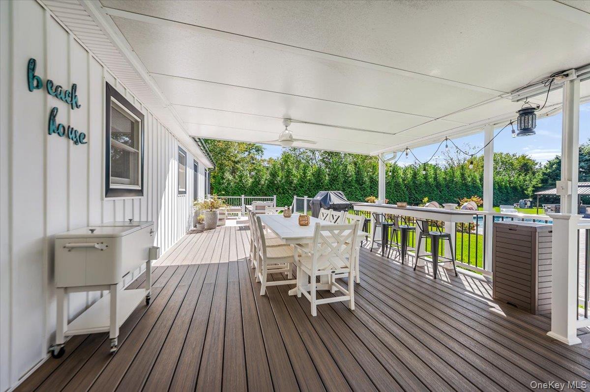 525 Rocky Point Road East Marion, NY 11939 - Photo 28 of 48 a view of a patio with table and chairs floor to ceiling window with wooden floor