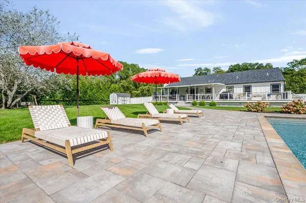 a view of a patio with a table and chairs under an umbrella