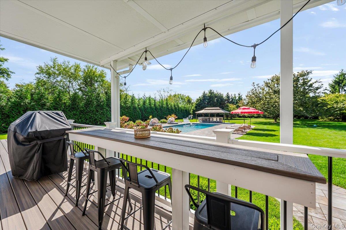 525 Rocky Point Road East Marion, NY 11939 - Photo 38 of 48 a view of a patio with table and chairs potted plants with wooden floor and fence