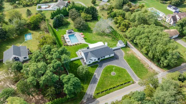an aerial view of residential houses with outdoor space and trees