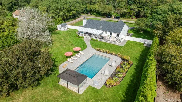 a aerial view of a house with a yard and large trees