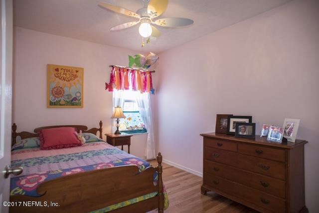 275 Jellison Road St. Augustine, FL 32080 - Photo 23 of 37 a bedroom with a bed and a chandelier