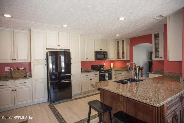 275 Jellison Road St. Augustine, FL 32080 - Photo 10 of 37 a kitchen with a refrigerator sink and cabinets