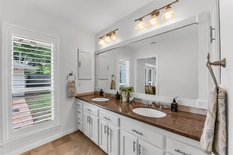 a bathroom with double vanity and a mirror