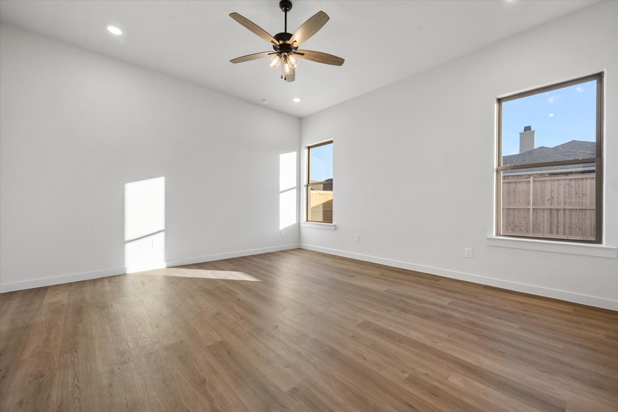 7007 56th Street Lubbock, TX 79407 - Photo 11 of 22 a view of an empty room with a window and wooden floor