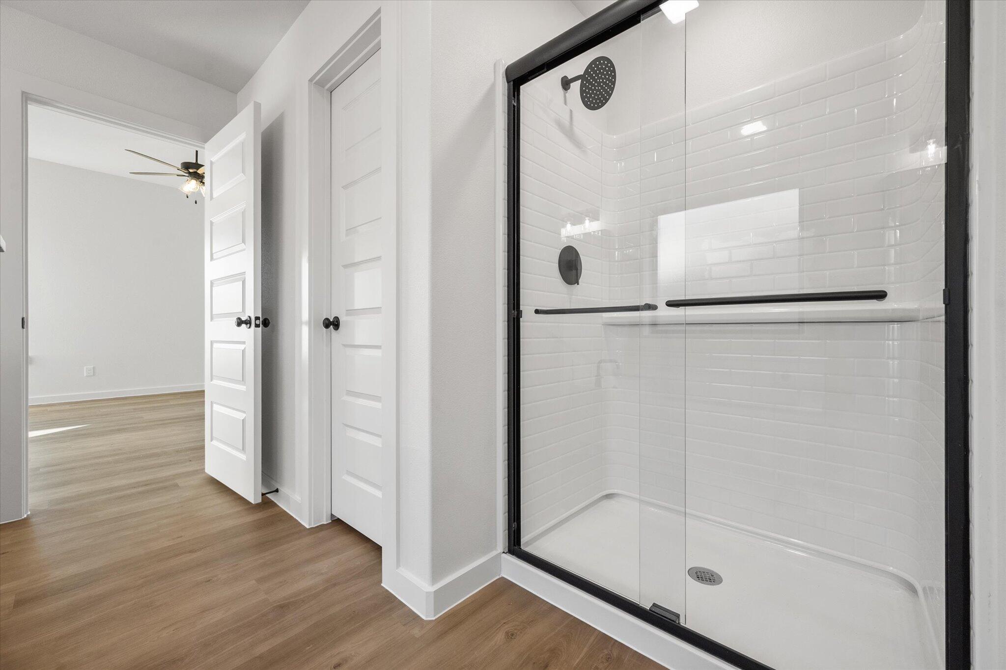 7007 56th Street Lubbock, TX 79407 - Photo 14 of 22 a bathroom with a glass shower door and a mirror