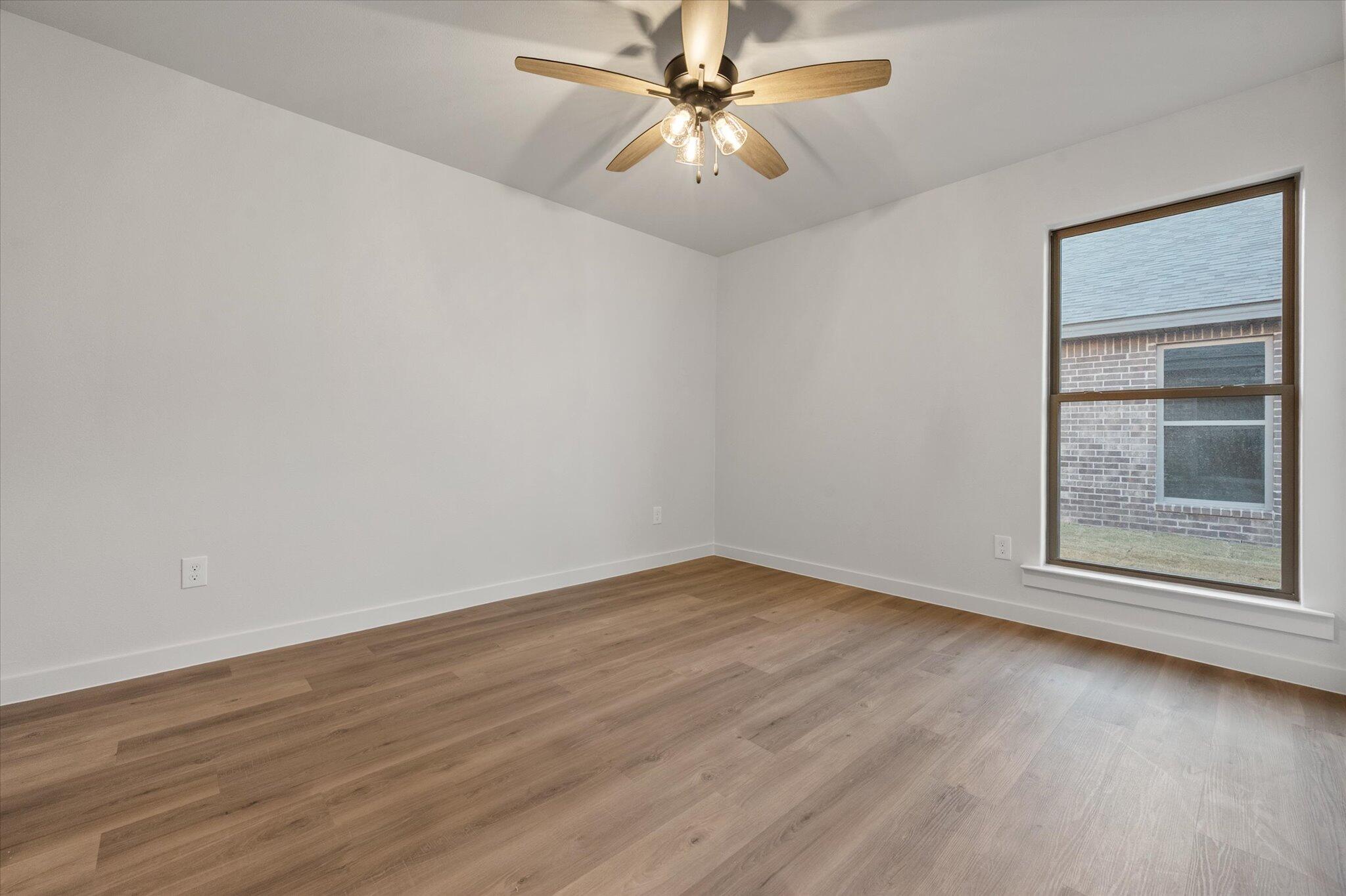 7007 56th Street Lubbock, TX 79407 - Photo 17 of 22 wooden floor in an empty room with a window