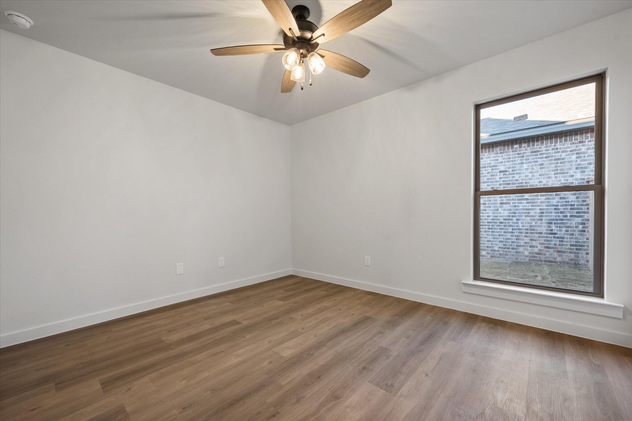 7007 56th Street Lubbock, TX 79407 - Photo 18 of 22 wooden floor in an empty room with a window