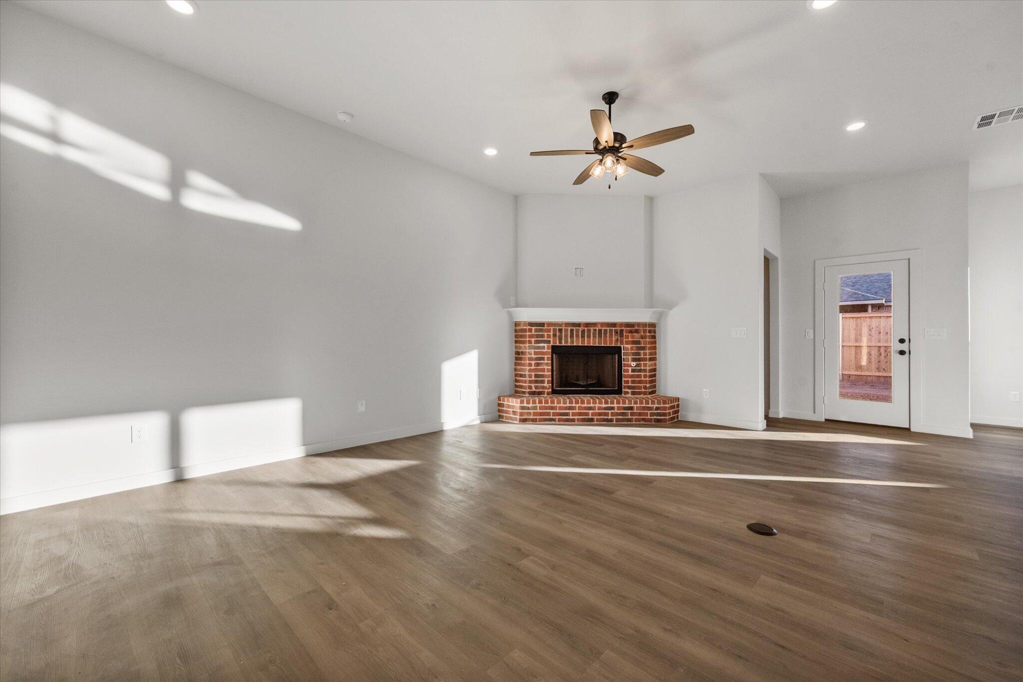 7007 56th Street Lubbock, TX 79407 - Photo 3 of 22 a view of an empty room with a fireplace and a window