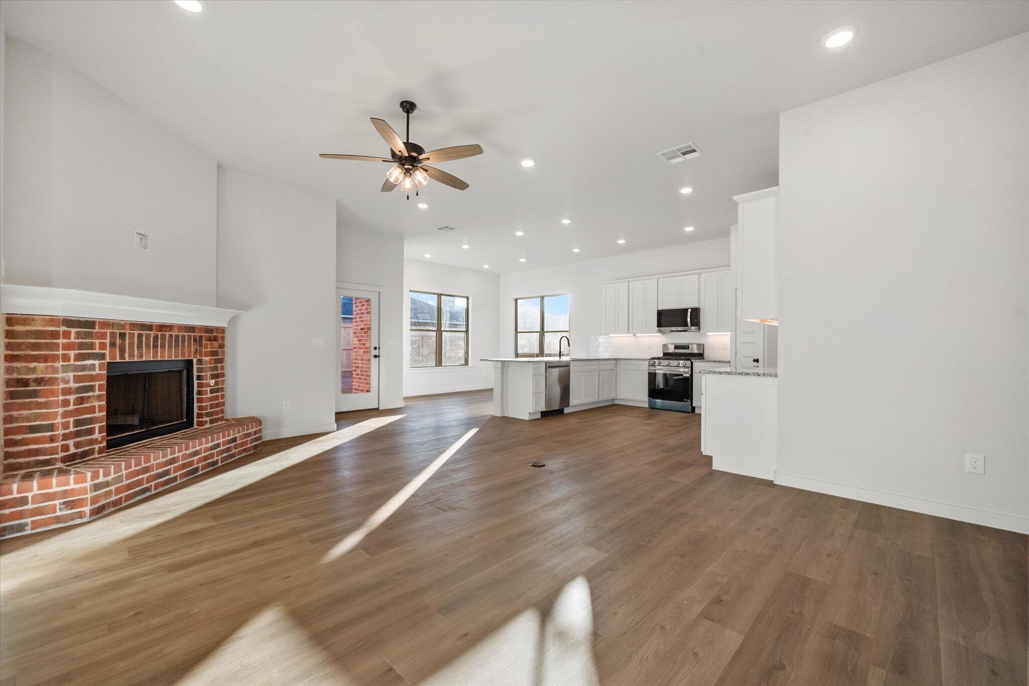 7007 56th Street Lubbock, TX 79407 - Photo 4 of 22 a view of a kitchen with a stove cabinets wooden floor and a kitchen