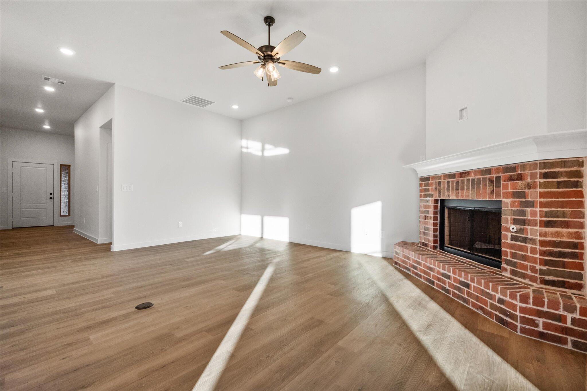 7007 56th Street Lubbock, TX 79407 - Photo 5 of 22 a view of an empty room with wooden floor fireplace and a window