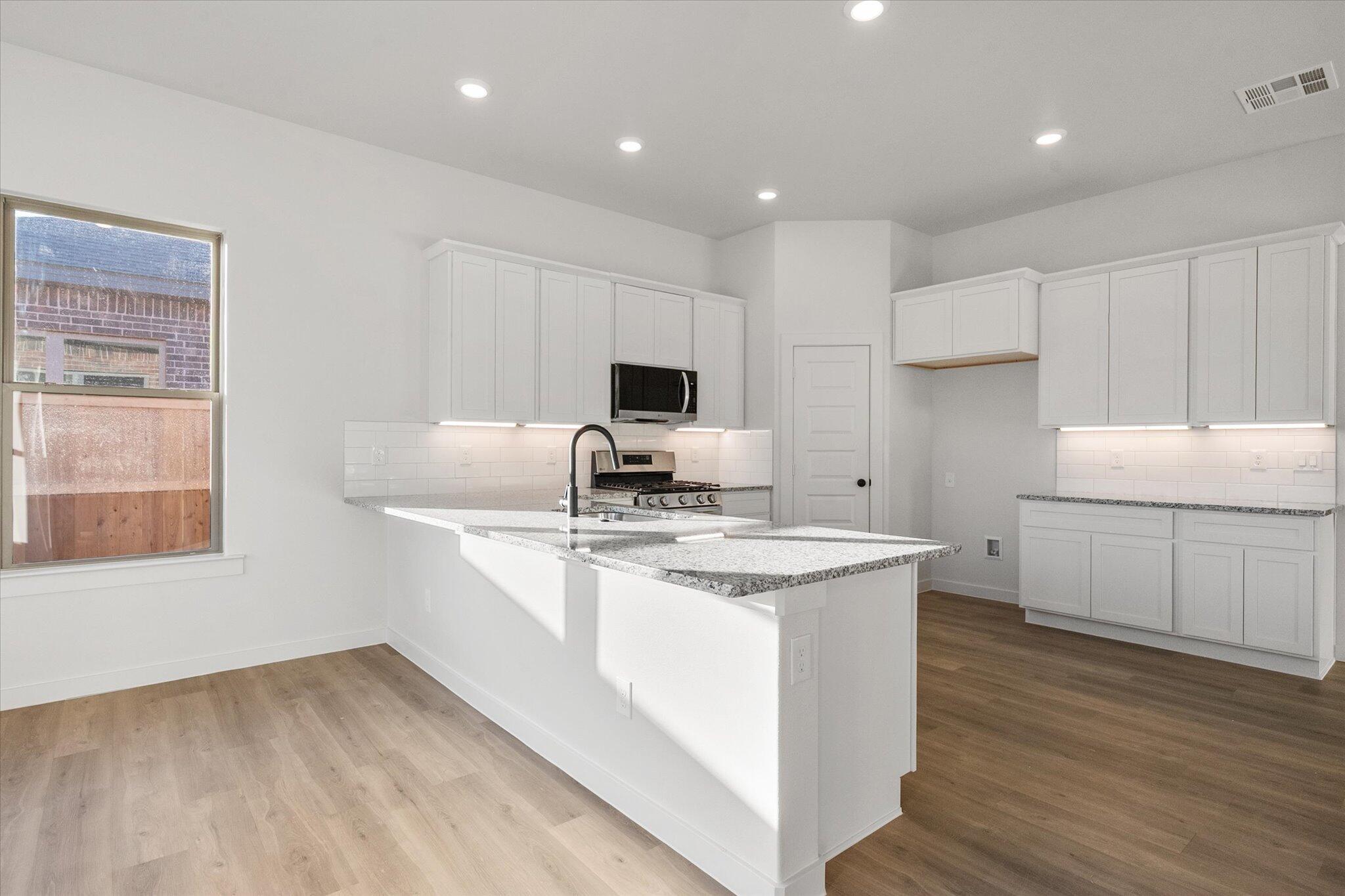 7007 56th Street Lubbock, TX 79407 - Photo 8 of 22 a kitchen with a sink stove and cabinets