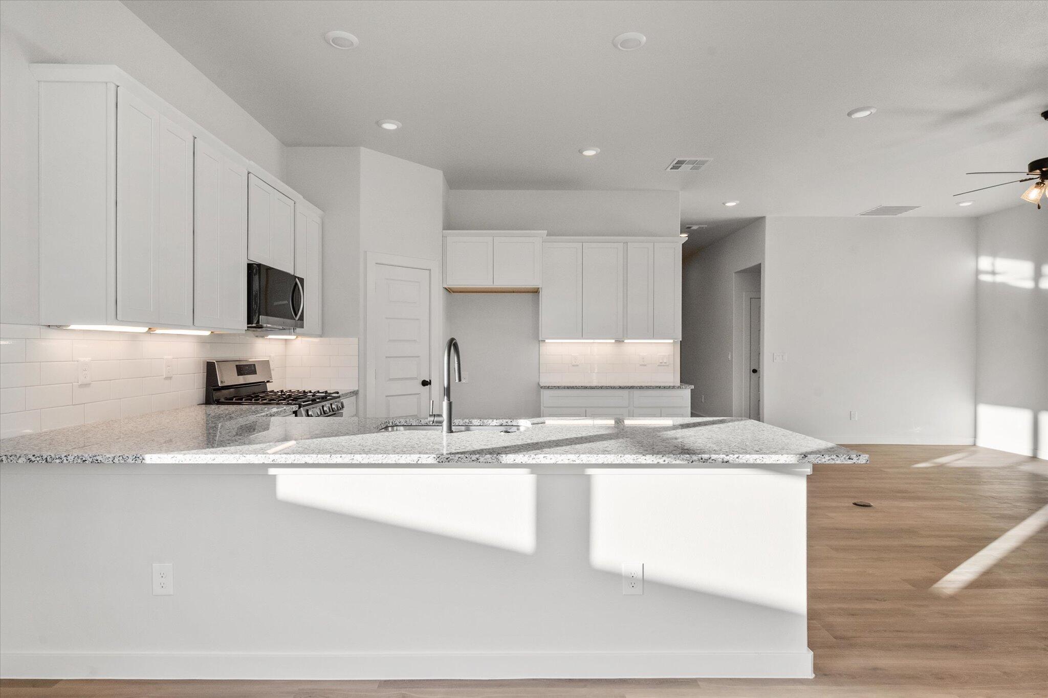 7007 56th Street Lubbock, TX 79407 - Photo 9 of 22 a view of kitchen with stainless steel appliances granite countertop a sink a stove and a granite counter top