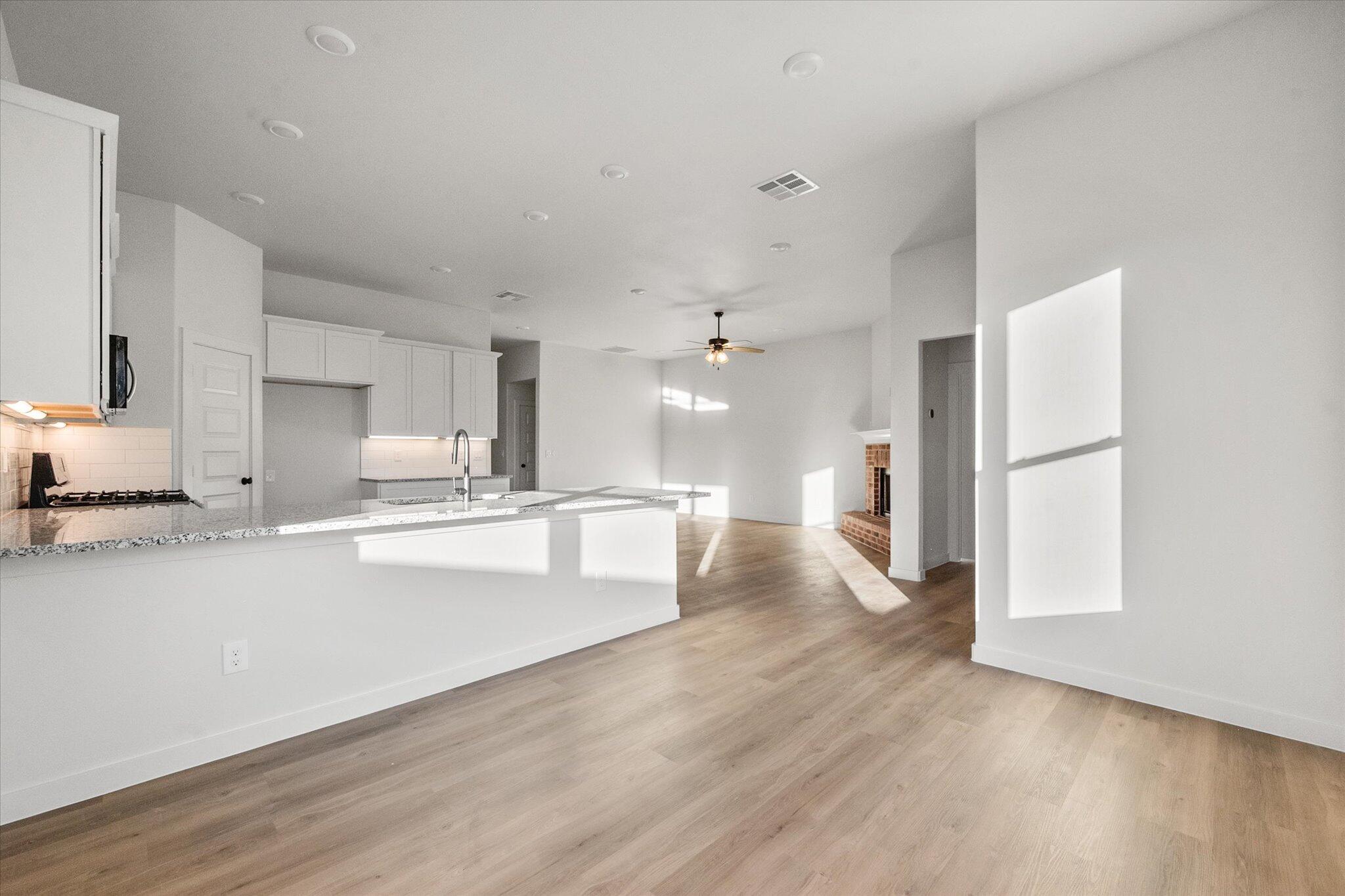 7007 56th Street Lubbock, TX 79407 - Photo 10 of 22 a large kitchen with a lot of white cabinets and stainless steel appliances