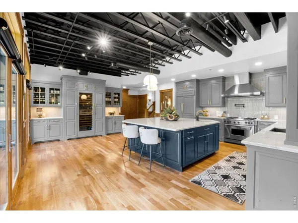 a kitchen with stainless steel appliances kitchen island granite countertop a sink cabinets and wooden floor