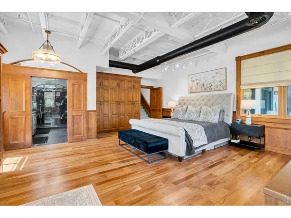 a spacious bedroom with a bed and a large mirror