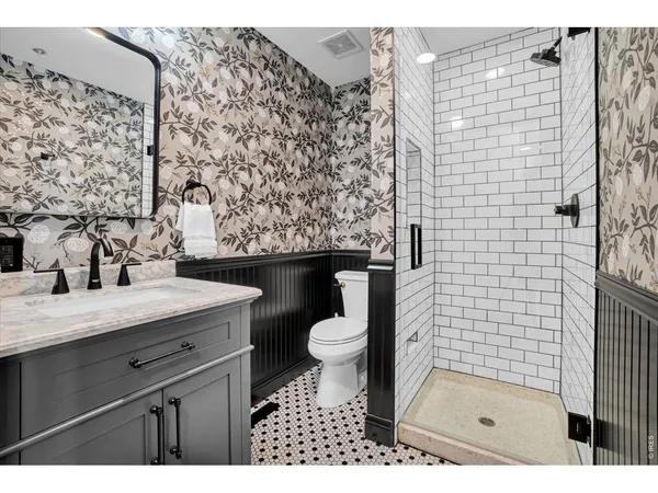 a bathroom with a granite countertop sink toilet and shower