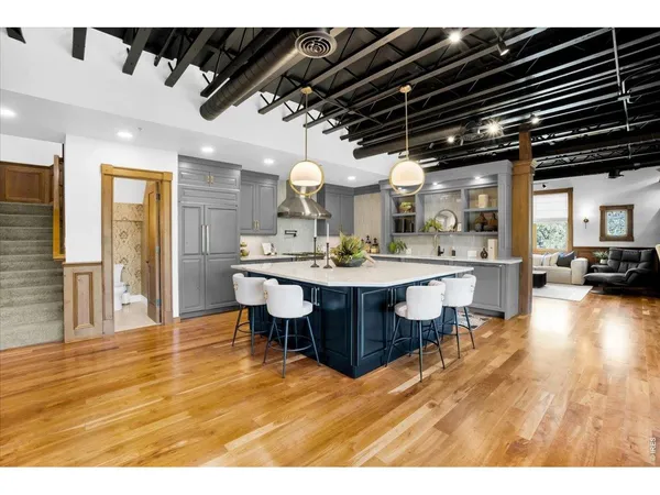 a dining hall with stainless steel appliances kitchen island a chandelier