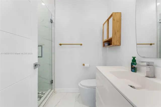 a bathroom with a sink a toilet and shower