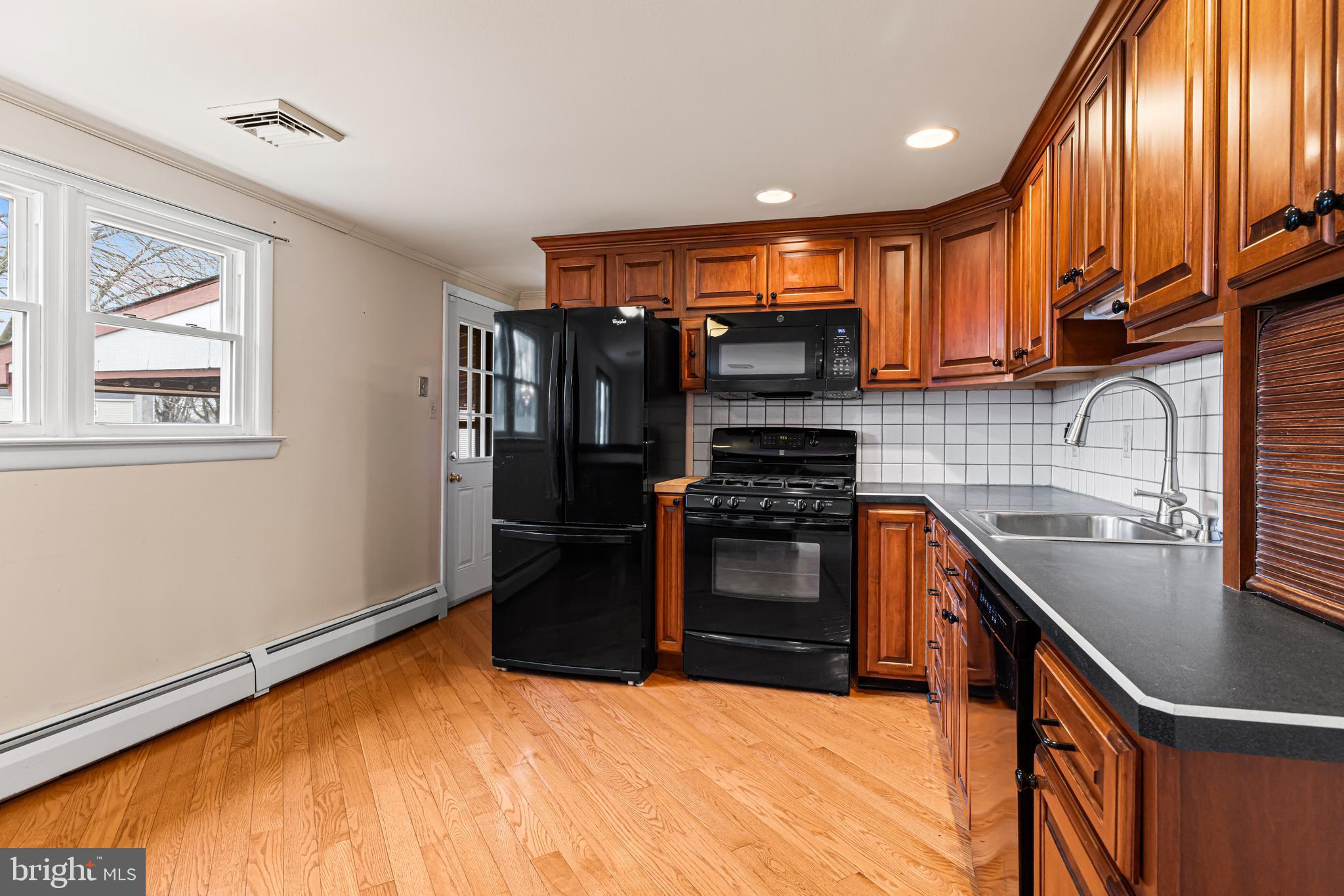 1413 Foster Road Warminster, PA 18974 - Photo 7 of 30 a kitchen with stainless steel appliances granite countertop a stove a sink and a refrigerator