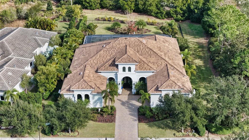 an aerial view of a house with a yard and large trees