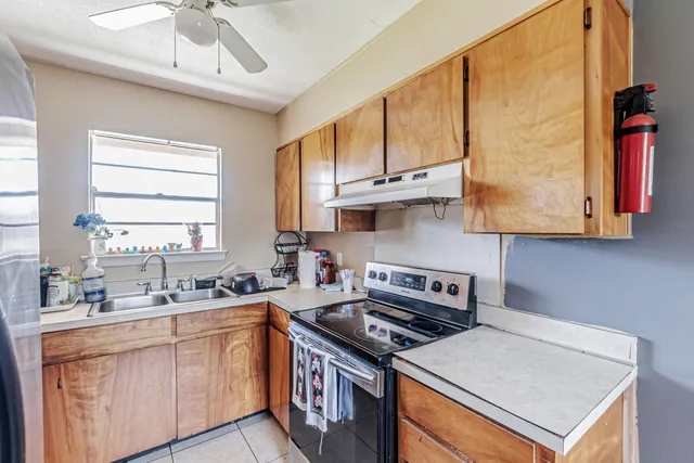 a kitchen with stainless steel appliances a sink a stove and a window