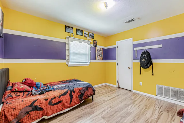 a bedroom with a bed and wooden floor