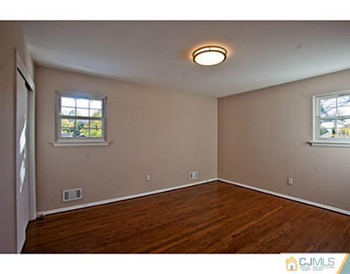 1991 Oak Tree Road Edison, NJ 08820 - Photo 13 of 20 a view of an empty room with wooden floor and a window