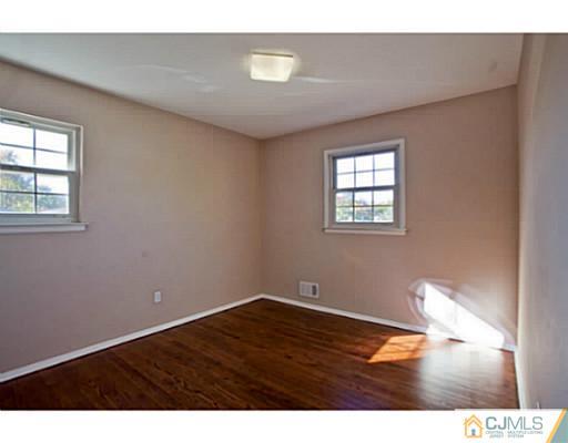 1991 Oak Tree Road Edison, NJ 08820 - Photo 14 of 20 a view of an empty room with wooden floor and a window