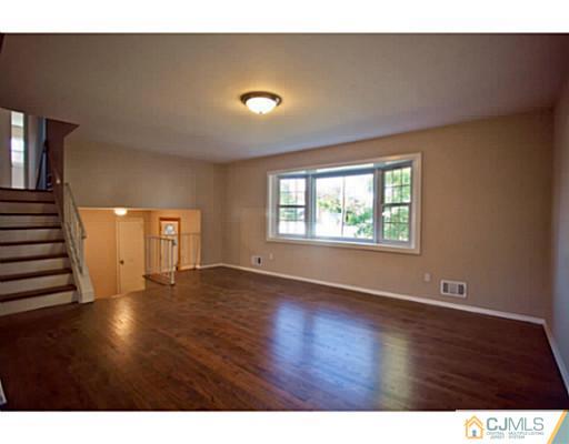 1991 Oak Tree Road Edison, NJ 08820 - Photo 3 of 20 a view of an empty room with wooden floor and a window