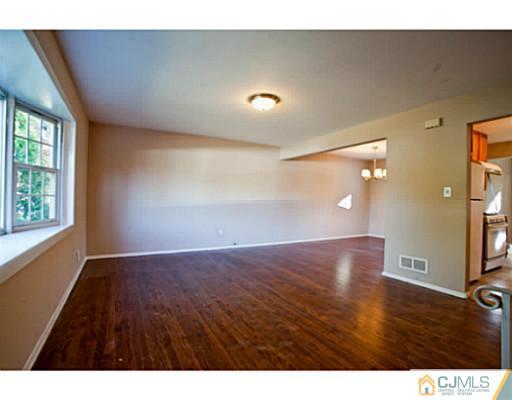 1991 Oak Tree Road Edison, NJ 08820 - Photo 4 of 20 a view of an empty room with wooden floor and a window