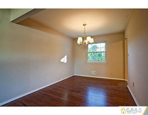 1991 Oak Tree Road Edison, NJ 08820 - Photo 8 of 20 a view of an empty room with window and wooden floor