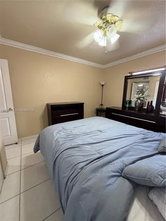 a bedroom with a bed and a dresser with wooden floor