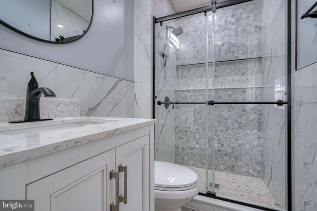 a bathroom with a granite countertop sink toilet and shower