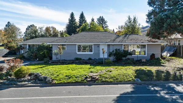 a front view of a residential houses with yard and green space