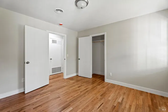 a view of empty room with wooden floor