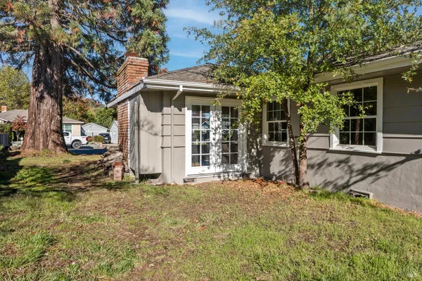a view of a house with backyard and sitting area