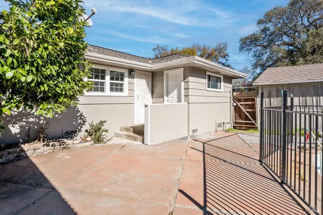 a white house with tree in front of it