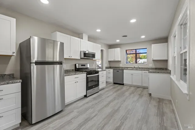 a kitchen with white cabinets and white appliances