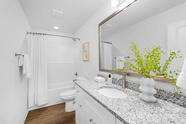 a bathroom with a granite countertop sink toilet and shower