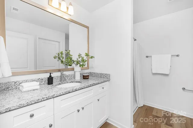 a bathroom with a granite countertop sink and a mirror