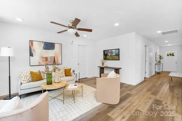 a living room with furniture and a wooden floor