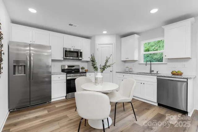 a kitchen with a refrigerator and a stove top oven
