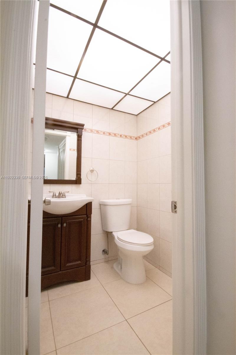 3000 Northwest 48th Terrace, Unit 322 Lauderdale Lakes, FL 33313 - Photo 12 of 15 a bathroom with a toilet sink and mirror