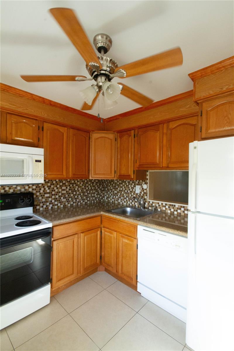 3000 Northwest 48th Terrace, Unit 322 Lauderdale Lakes, FL 33313 - Photo 4 of 15 a kitchen with granite countertop a sink and cabinets
