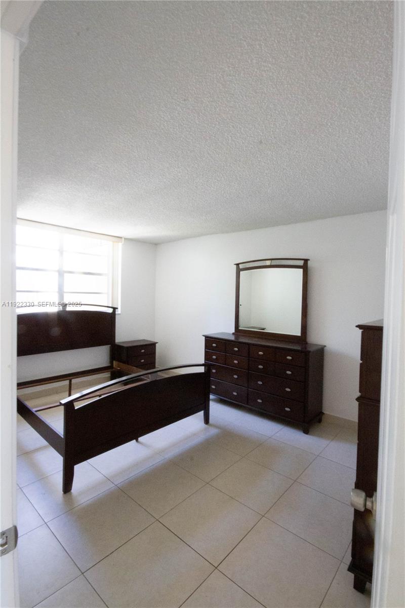 3000 Northwest 48th Terrace, Unit 322 Lauderdale Lakes, FL 33313 - Photo 10 of 15 a bedroom with a bed and a flat screen tv
