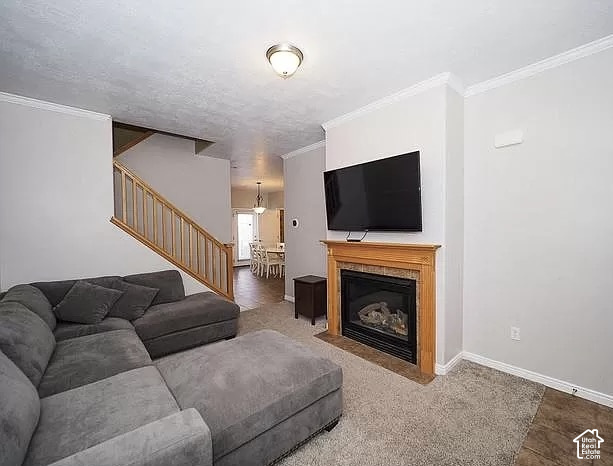13548 South Villa Rosa Way Draper, UT 84020 - Photo 2 of 28 Built-in fireplace with a wood mantle and tile surround, complemented by crown molding and a staircase with wood railing