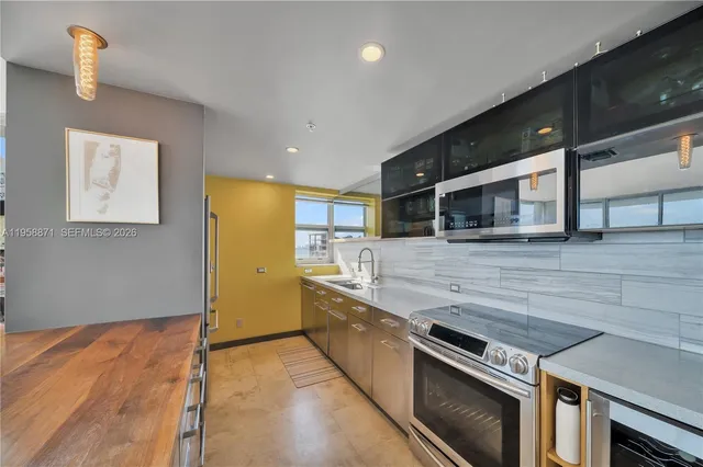 a kitchen with stainless steel appliances and wooden floor