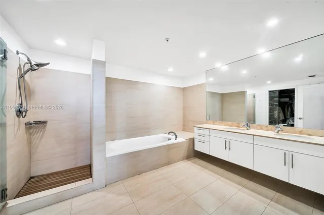 a large spacious bathroom with a large tub shower and sink